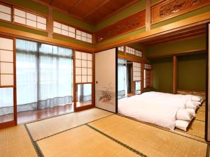 una camera da letto con un letto grande in una stanza con finestre di 旅館紀の国 