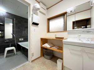 un bagno con lavandino, vasca e doccia di 旅館紀の国  Altre 74 foto