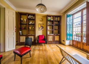a living room with red chairs and bookshelves at Hostel Covent Garden in León