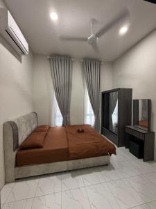 een slaapkamer met een bed en een televisie. bij Eyqa Homestay Pasir Mas in Pasir Mas