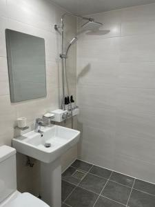 een witte badkamer met een wastafel en een douche bij Haemil Stay in Daegu