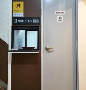 een deur met een bord naast een raam bij Haemil Stay in Daegu