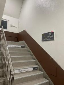 een trap in een gebouw met een bord aan de muur bij Haemil Stay in Daegu