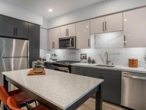 een keuken met een tafel en een roestvrijstalen koelkast bij Magic Key Two-Bedroom Escape Near Disneyland With Free Parking in Anaheim