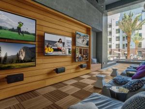 een woonkamer met drie televisies aan de muur bij Magic Key Two-Bedroom Escape Near Disneyland With Free Parking in Anaheim