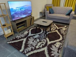 uma sala de estar com um sofá e uma TV em 2 Bedroom House at Ayi Mensah Park em Aiyimensa