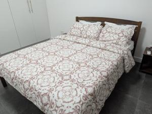 um quarto com uma cama com um edredão e almofadas em 2 Bedroom House at Ayi Mensah Park em Aiyimensa