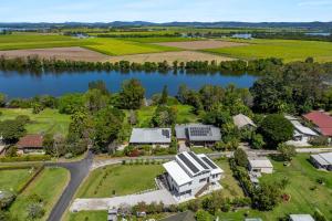 een luchtfoto van een huis naast een meer bij The Grevilleas in Woombah