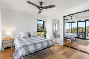 een slaapkamer met een bed en een plafondventilator bij The Grevilleas in Woombah
