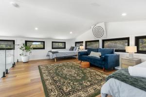 een woonkamer met een blauwe stoel en een bank bij The Grevilleas in Woombah