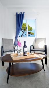 een tafel met een fles wijn en twee stoelen bij Three Monkeys Mae Nam beach in Nathon Bay