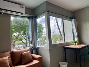 a living room with a couch and two windows at Amazing Inn Koh Phangan in Thong Sala