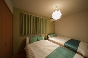 a room with two beds and a chandelier at Triangle 2nd in Beppu
