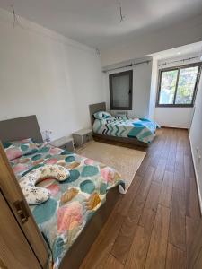 een slaapkamer met twee bedden en een flatscreen-tv bij Grands appartement 3 chambres à résidence Valmascort, Annaba in Annaba