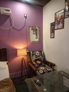 a room with a chair and a table with a lamp at Gorakhnath Guest House in Gorakhpur