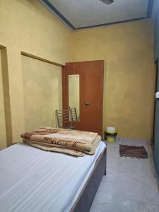 a bedroom with a bed with a wooden door at Gorakhnath Guest House in Gorakhpur