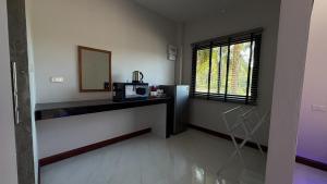 een keuken met een aanrecht met een magnetron en een raam bij PS Lanta Resort 