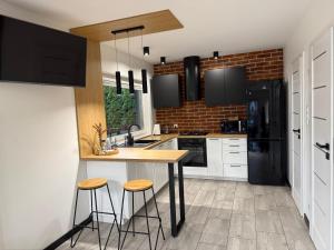 een keuken met witte kasten en een aanrecht met krukken bij Domek Kaszuby Stężyca z banią i sauną in Stężyca