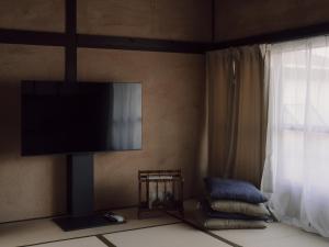 a living room with a flat screen tv on the wall at 千秋楽 in Tamano