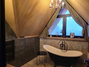 ein Badezimmer mit Badewanne und Fenster in der Unterkunft Białczańskie Bacówki 2, 4sypialnie in Białka Tatrzańska