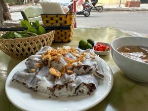 a plate of food on a table with a bowl of soup at Hoa Hồng 301MD in Hanoi