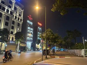 a city street at night with people riding motorcycles at Hoa Hồng 301MD in Hanoi