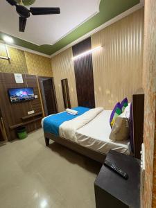 a hotel room with a bed and a tv at AD ressidency Hotel in Agra
