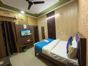 a bedroom with a bed and a tv in it at AD ressidency Hotel in Agra