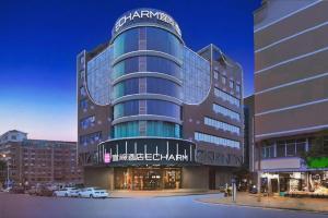 een groot gebouw met auto's ervoor geparkeerd bij Echarm Hotel Changsha Wuyi Square Xiangya Affiliated 1st Provincial Maternity and Child in Changsha