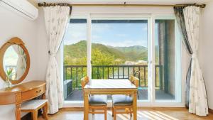 een eetkamer met een tafel en een groot raam bij Gapyeong Elin Pension in Gapyeong