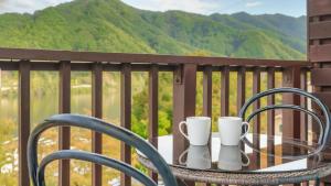 een tafel met 2 kopjes en stoelen op een balkon bij Gapyeong Elin Pension in Gapyeong +1 foto