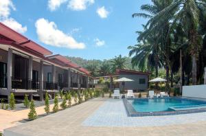 a resort with a swimming pool and palm trees at PS Lanta Resort in Phra Ae beach