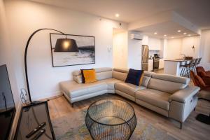 een woonkamer met een bank en een tafel bij 205 - Modern Suite - Pool and River View in Baie-Saint-Paul