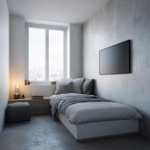 a bedroom with a bed with a television on the wall at rõõm collective in Odiongan