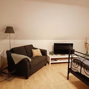 uma sala de estar com um sofá e uma TV de tela plana em Urban Apple em Bad Mergentheim