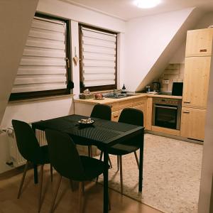 uma cozinha com uma mesa preta e cadeiras em Urban Apple em Bad Mergentheim