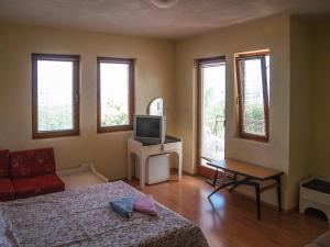 a bedroom with a bed and a tv and windows at Galija in Struga