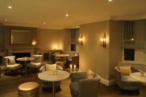 a restaurant with tables and chairs and a fireplace at New Bath Hotel & Spa in Matlock