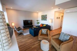 a living room with a blue couch and chairs at 209 - Luxury Condo - Pool & River View in Baie-Saint-Paul +47 photos