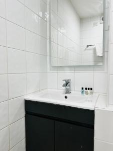 een witte badkamer met een wastafel en een spiegel bij Crown Hotel - Stone, Near Stoke-On-Trent by OYO in Stone