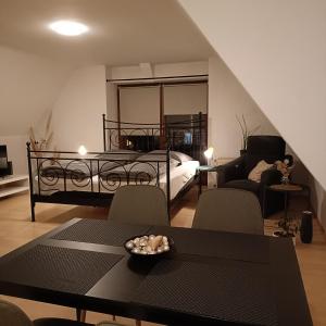 uma sala de estar com uma cama, uma mesa e cadeiras em Urban Apple em Bad Mergentheim