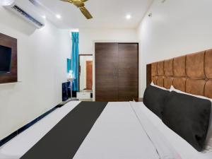 ein Schlafzimmer mit einem großen Bett und einer Holztür in der Unterkunft Super Hotel O Arjun Residency in Khammam + 33 Fotos