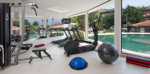 a fitness room with a gym with a swimming pool at Angra Boutique Hotel in Angra dos Reis