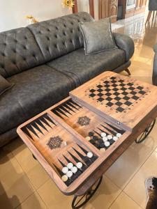 桑丹斯基Мезонет “Djanina”的客厅配有沙发和棋盘(桌子上)