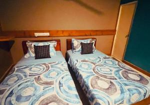 two beds sitting next to each other in a room at Kandoo Cozy Family Room in Huraa