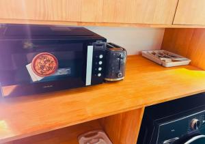 a microwave sitting on a counter with a bowl of pizza at Kandoo Cozy Family Room in Huraa +2 photos