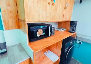 a microwave sitting on a wooden counter in a kitchen at Kandoo Cozy Family Room in Huraa