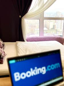 un ordinateur portable posé sur une table devant un lit dans l'établissement sixkeys- studioLebedinyy, à Kiev