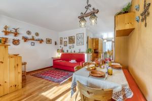 a living room with a table and a red couch at Appartamento Big Lem - Happy Rentals in Sauze d'Oulx