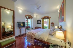 een slaapkamer met een bed en een flatscreen-tv bij Neemrana's Three Waters in Betul